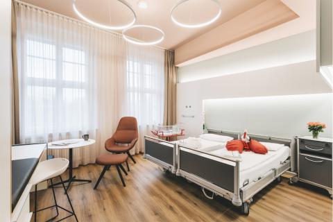 Blick in ein Wahlleistungszimmer im Krankenhaus St. Joseph-Stift Dresden: Hier ein Familienzimmer auf der Geburtsstation mit Doppelbett und Babybett.
