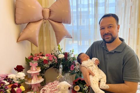 Die kleine Hosna ist das 1000. Baby in 2026 im St. Joseph-Stift. Hier posiert ihr Vater Hamid mit ihr auf dem Arm auf dem Zimmer der Wochenstation.